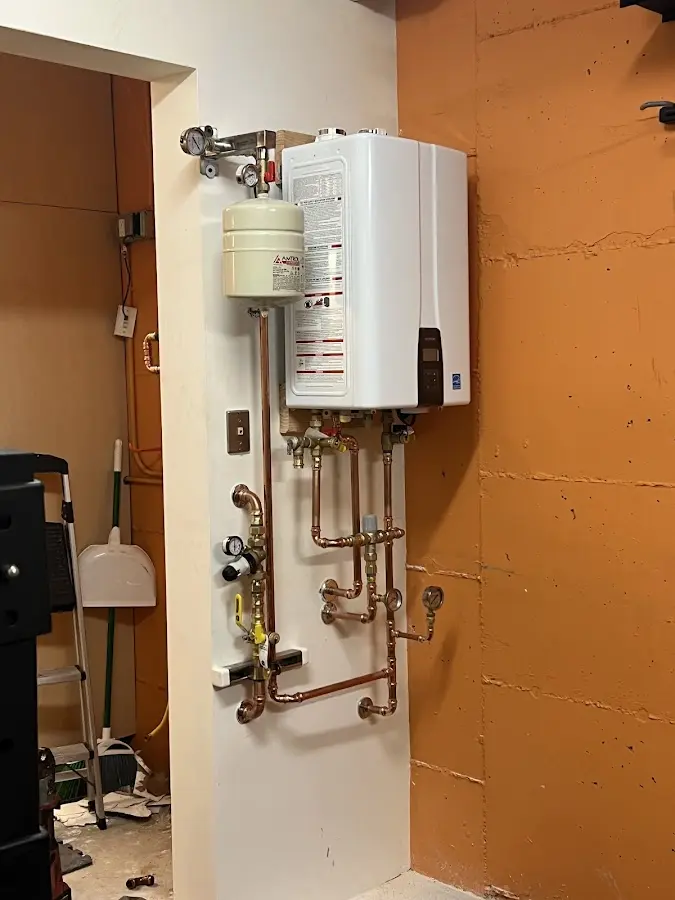 Plumbing technician inspecting water heater connections in Crystal City